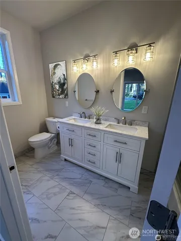 a bathroom with a double vanity sink and a mirror