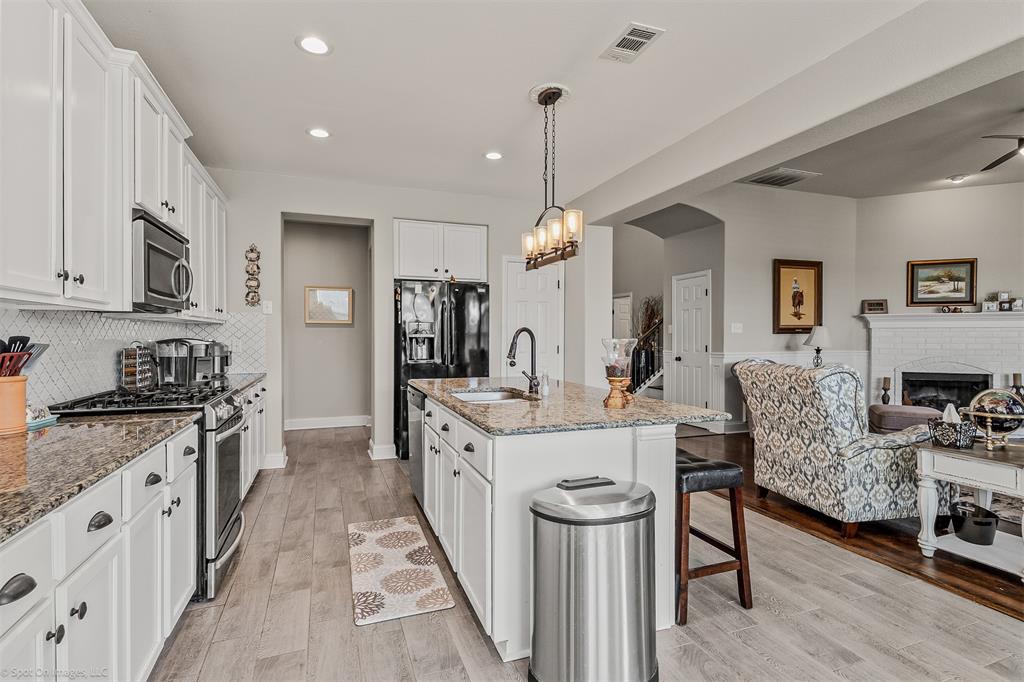 766 Sycamore Trail Forney, TX 75126 - Photo 14 of 37 a large kitchen with stainless steel appliances kitchen island granite countertop a sink and cabinets