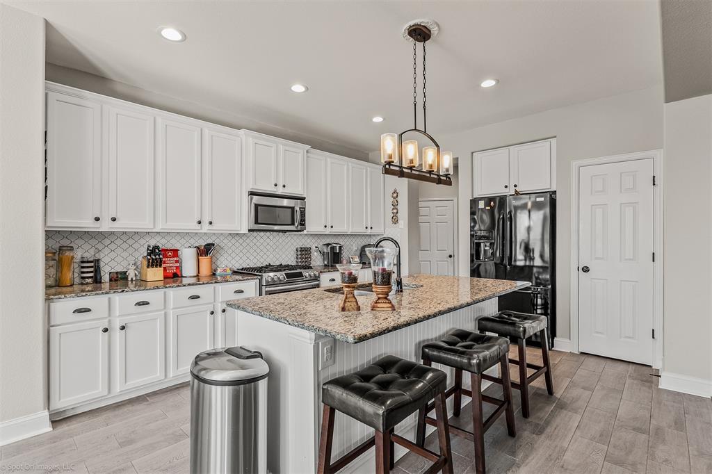 766 Sycamore Trail Forney, TX 75126 - Photo 4 of 37 a open kitchen with stainless steel appliances granite countertop a sink a stove a refrigerator and white cabinets