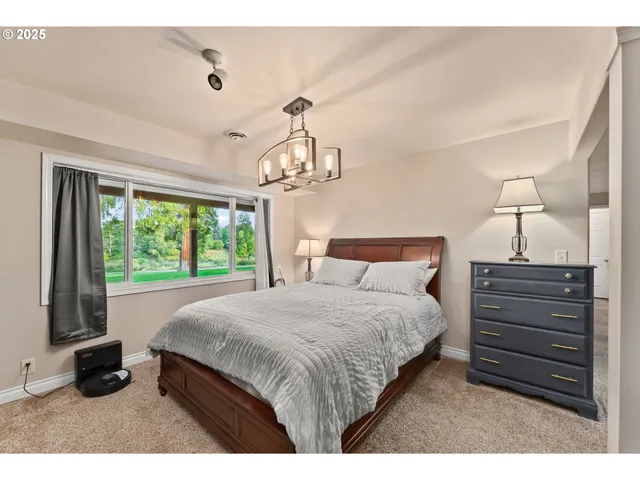 a bedroom with a bed and a large window