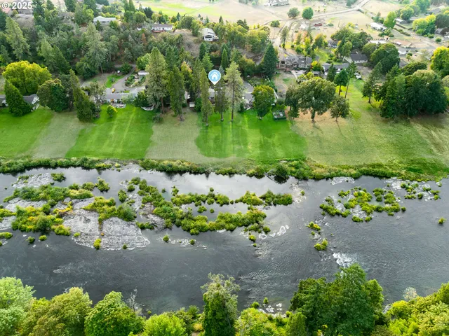 an aerial view of a houses with a yard and lake view