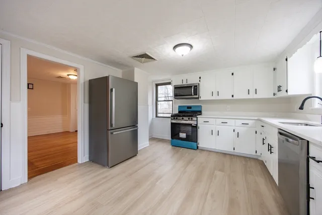 a kitchen with stainless steel appliances a refrigerator sink and cabinets