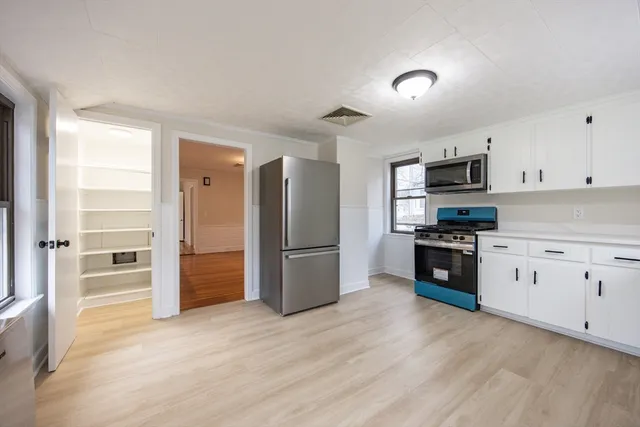 a kitchen with granite countertop a refrigerator and a stove top oven