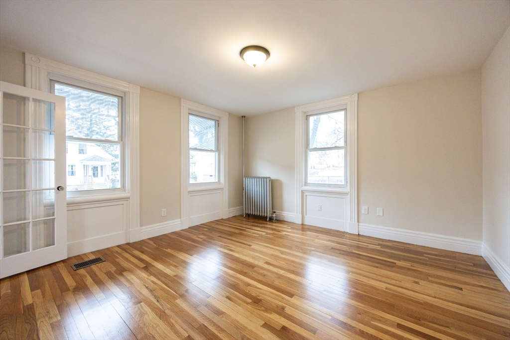 57 Pine Street Milford, MA 01757 - Photo 8 of 29 a view of an empty room with wooden floor and a window