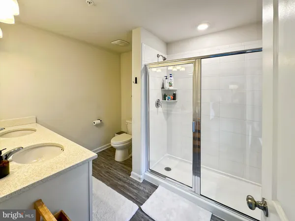 a bathroom with a granite countertop sink toilet and shower