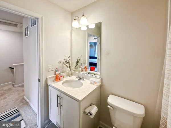 a bathroom with a sink a toilet and shower curtain