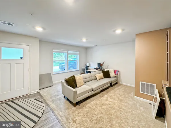 a kitchen with stainless steel appliances kitchen island granite countertop a table chairs and a refrigerator