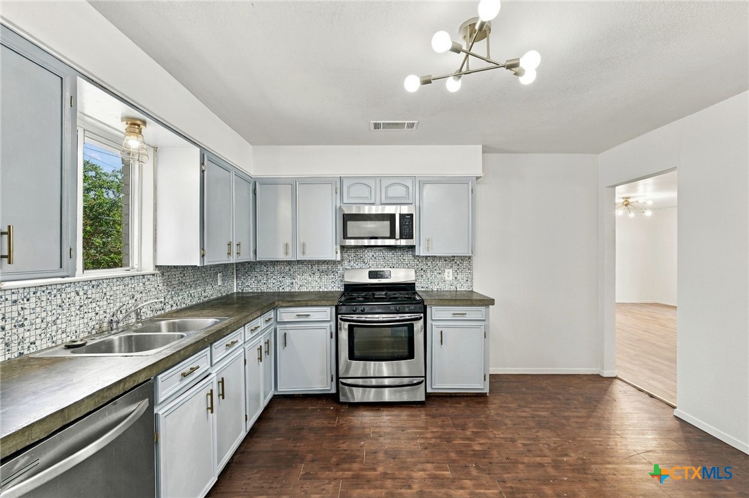 904 Kirk Street Taylor, TX 76574 - Photo 11 of 25 Kitchen with easy access to the living room & a view of the backyard from the window.