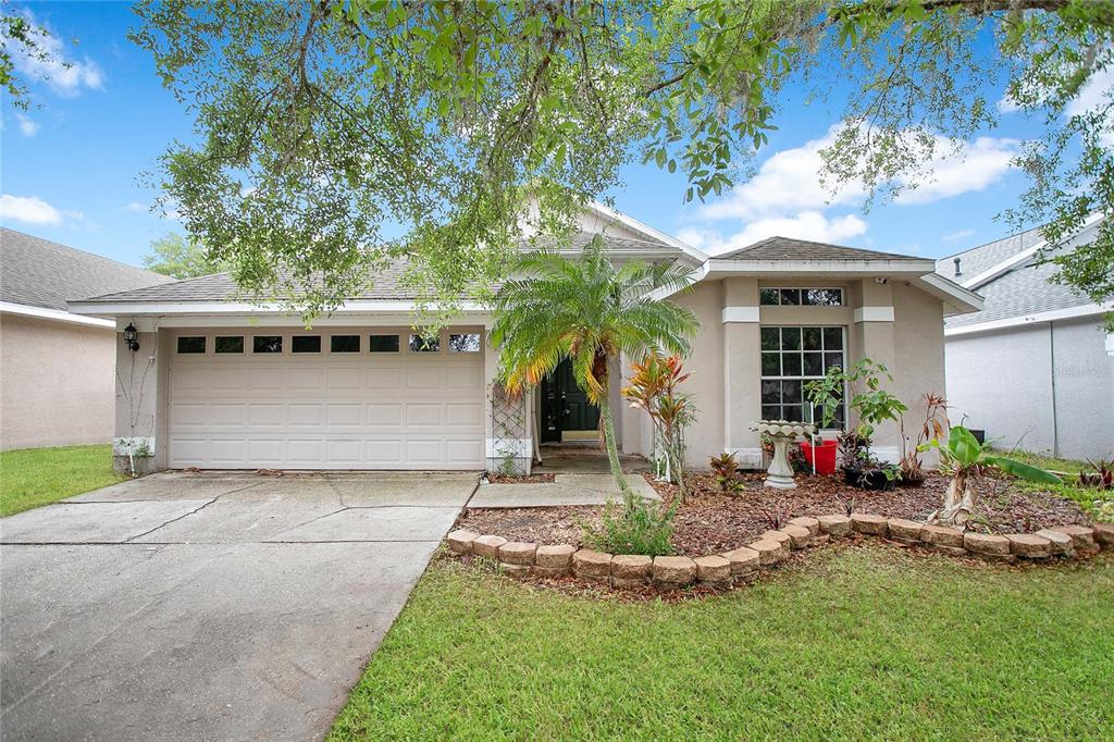 16829 Hawkridge Road Lithia, FL 33547 - Photo 1 of 1 a front view of a house with a yard garage and outdoor seating
