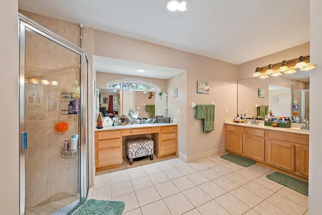 a bathroom with a double vanity sink mirror and shower