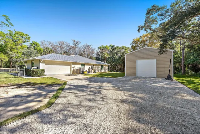 a view of a house with a yard and large tree