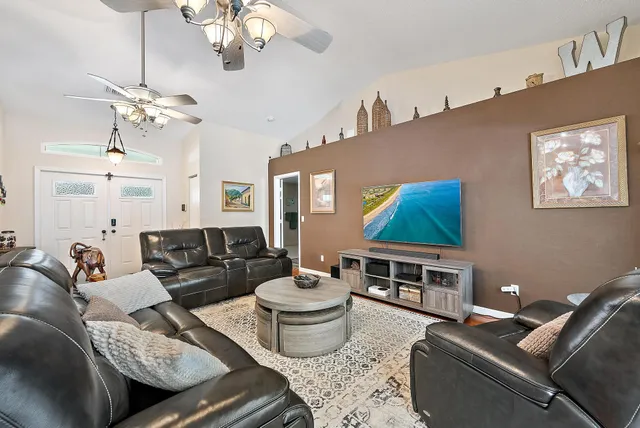 a living room with furniture a chandelier and a flat screen tv