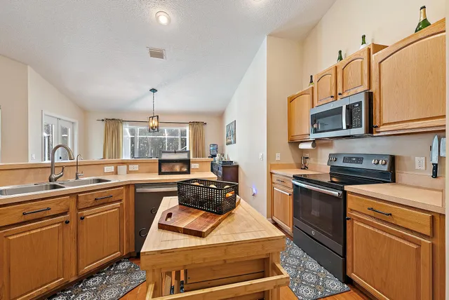 a kitchen with stainless steel appliances a stove sink microwave and cabinets