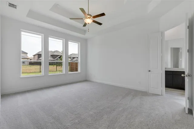 an empty room with windows and ceiling fan