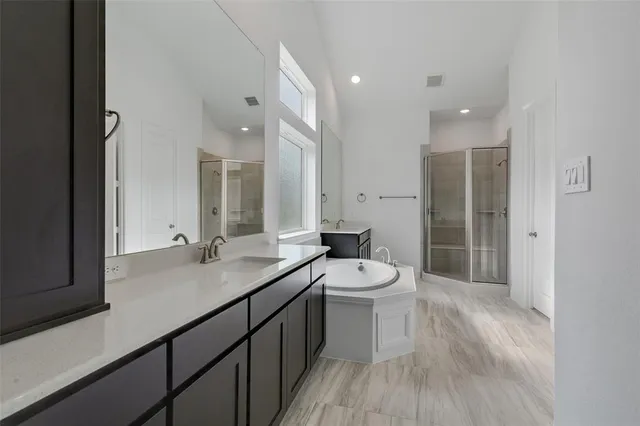 a bathroom with a sink a toilet a large mirror and shower