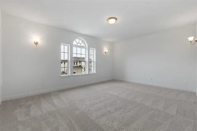 an empty room with windows and ceiling fan view