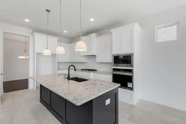 a kitchen with kitchen island a sink stainless steel appliances and cabinets