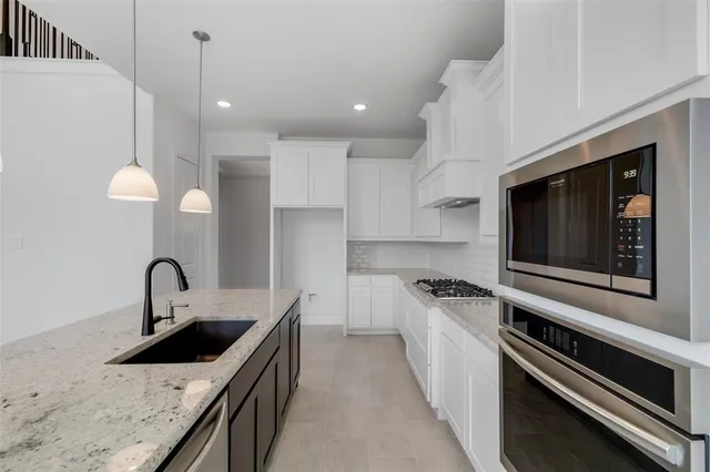 a kitchen with granite countertop a sink and stove top oven