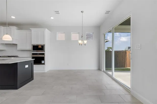 a kitchen with kitchen island granite countertop a stove a sink and a refrigerator with wooden floor