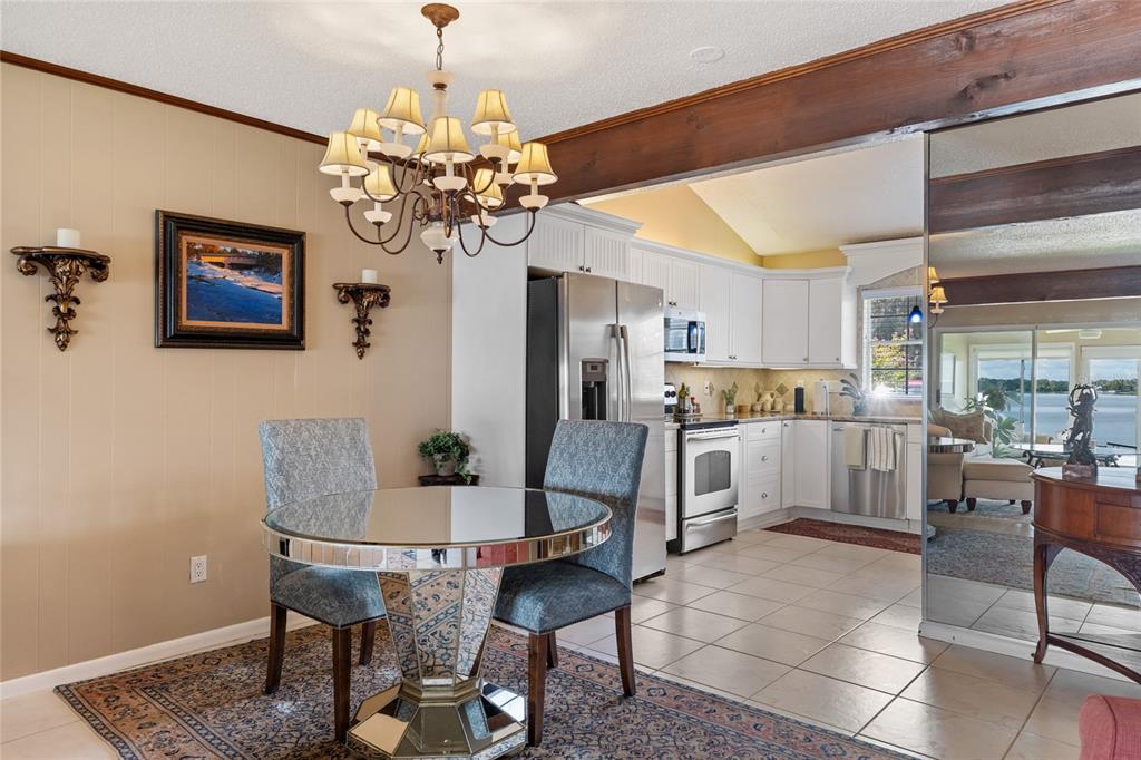 11001 Southeast Sunset Harbor Road, Unit B13 Summerfield, FL 34491 - Photo 15 of 50 a dining room filled chandelier and kitchen view