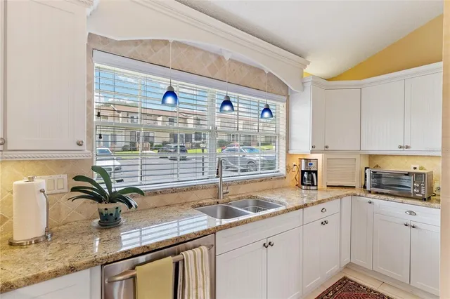 a kitchen with granite countertop a sink and a window