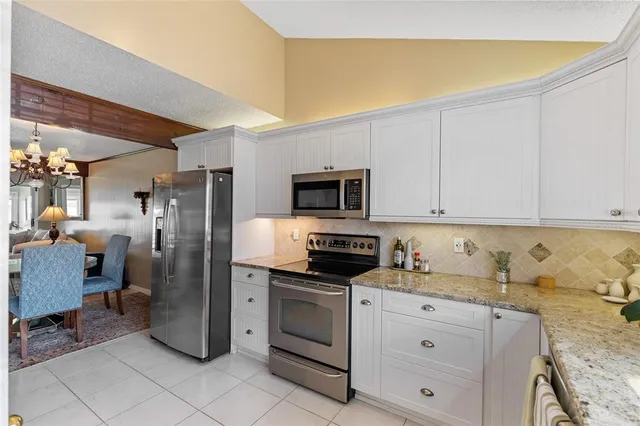 a kitchen with stainless steel appliances granite countertop a refrigerator sink and stove