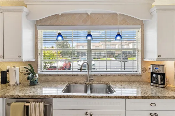 a kitchen with granite countertop a sink and a window