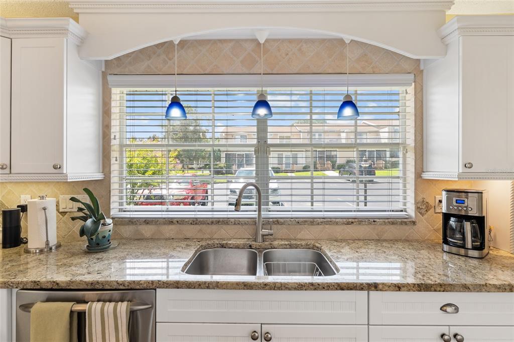 11001 Southeast Sunset Harbor Road, Unit B13 Summerfield, FL 34491 - Photo 21 of 50 a kitchen with granite countertop a sink and a window