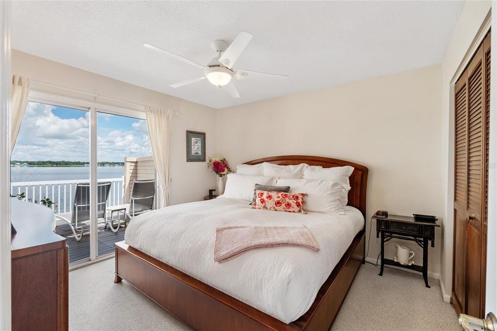 11001 Southeast Sunset Harbor Road, Unit B13 Summerfield, FL 34491 - Photo 25 of 50 a bedroom with a bed and a large window