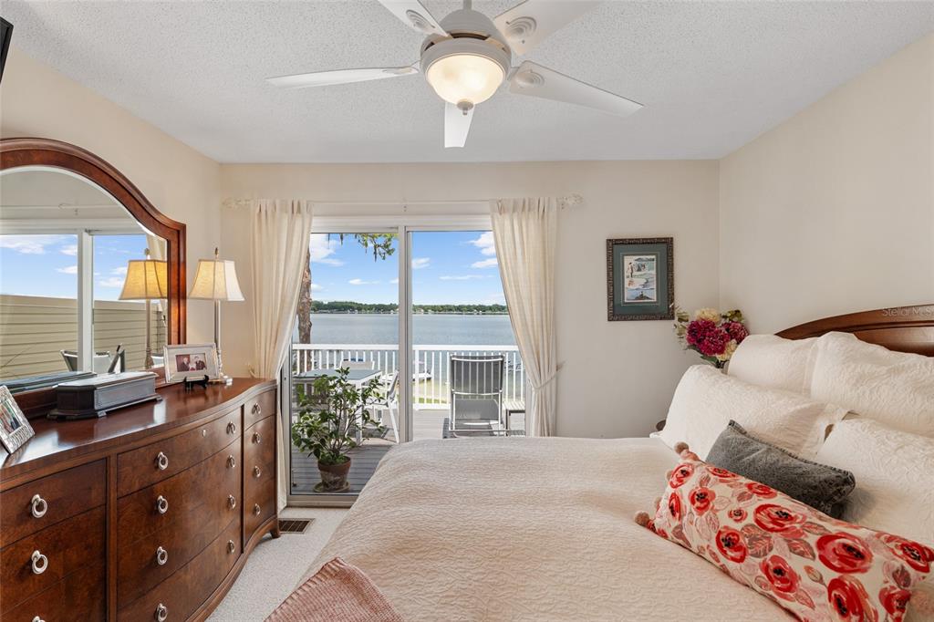 11001 Southeast Sunset Harbor Road, Unit B13 Summerfield, FL 34491 - Photo 27 of 50 a bedroom with a bed and a chandelier