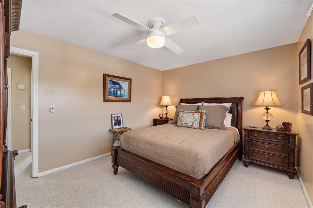 11001 Southeast Sunset Harbor Road, Unit B13 Summerfield, FL 34491 - Photo 34 of 50 a bedroom with a bed and a chandelier