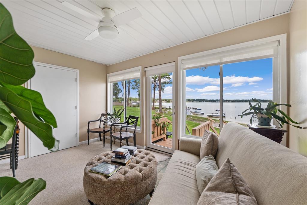 11001 Southeast Sunset Harbor Road, Unit B13 Summerfield, FL 34491 - Photo 38 of 50 a living room with furniture and a large window with garden view