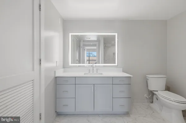 a bathroom with a toilet a sink and mirror