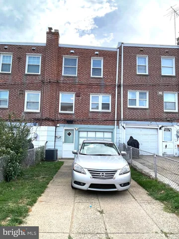 a car parked in front of a brick house