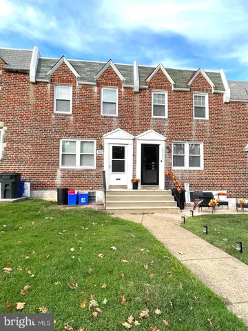 a view of a house with a yard and sitting area