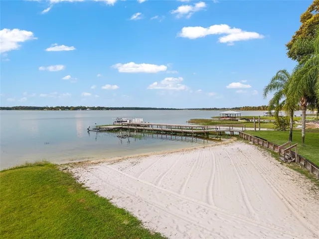 a front view of a house with a yard and potted plants