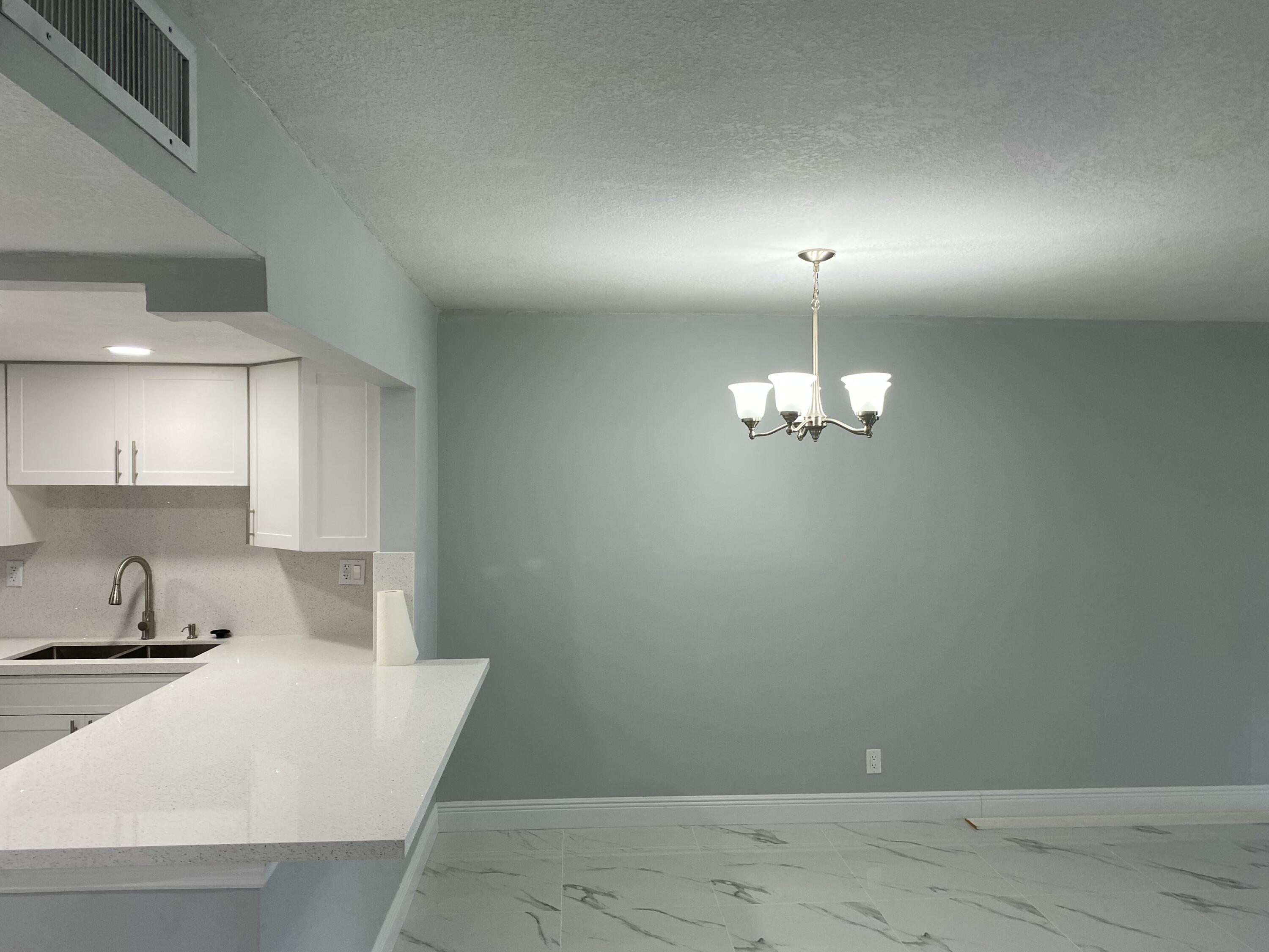 2788 Tennis Club Drive, Unit 102 West Palm Beach, FL 33417 - Photo 18 of 26 an empty room with wooden floor and windows