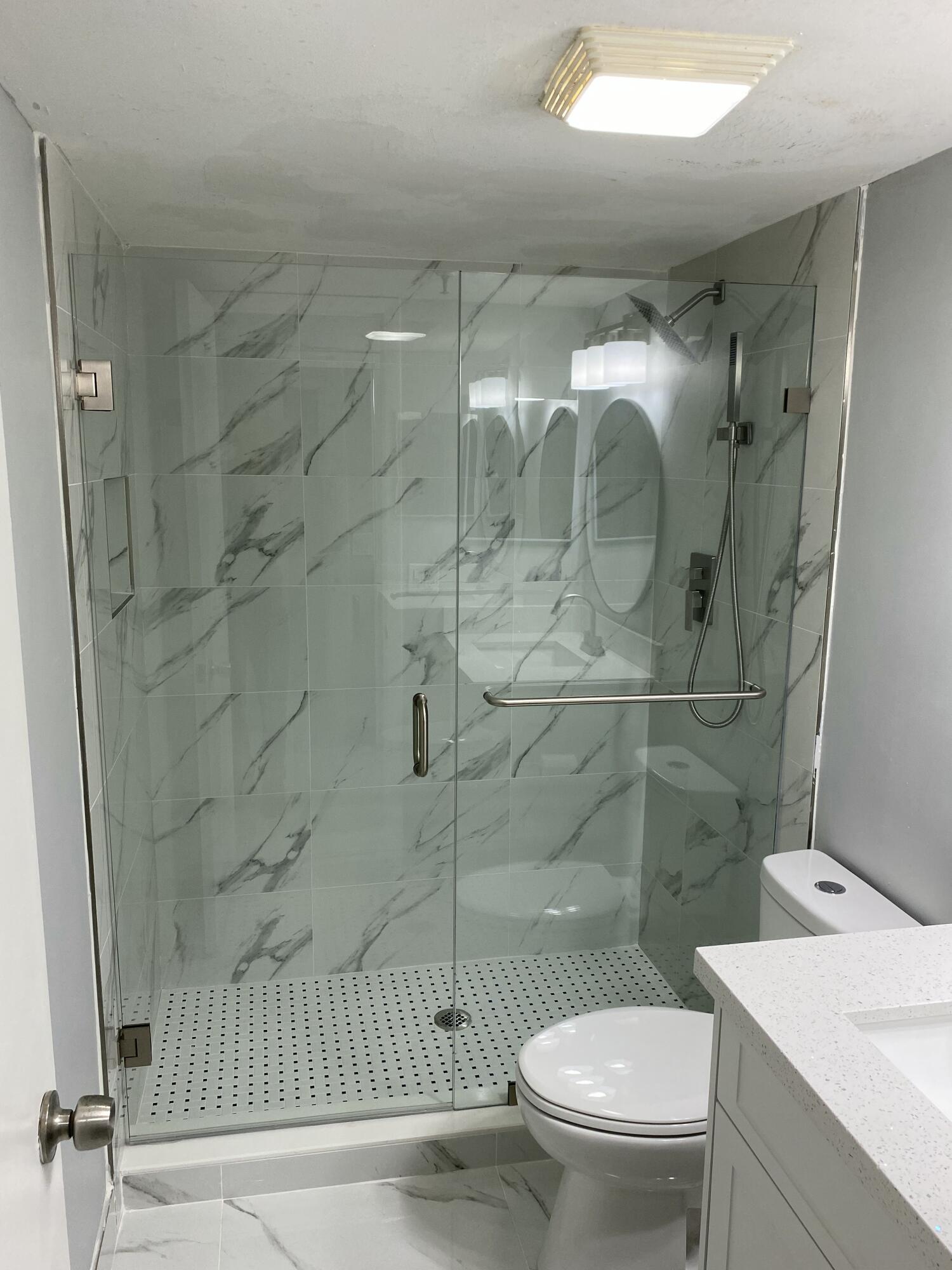 2788 Tennis Club Drive, Unit 102 West Palm Beach, FL 33417 - Photo 22 of 26 a bathroom with a toilet and a shower