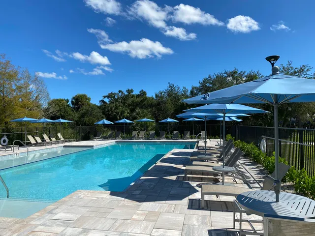 a view of a patio with table and chairs under an umbrella