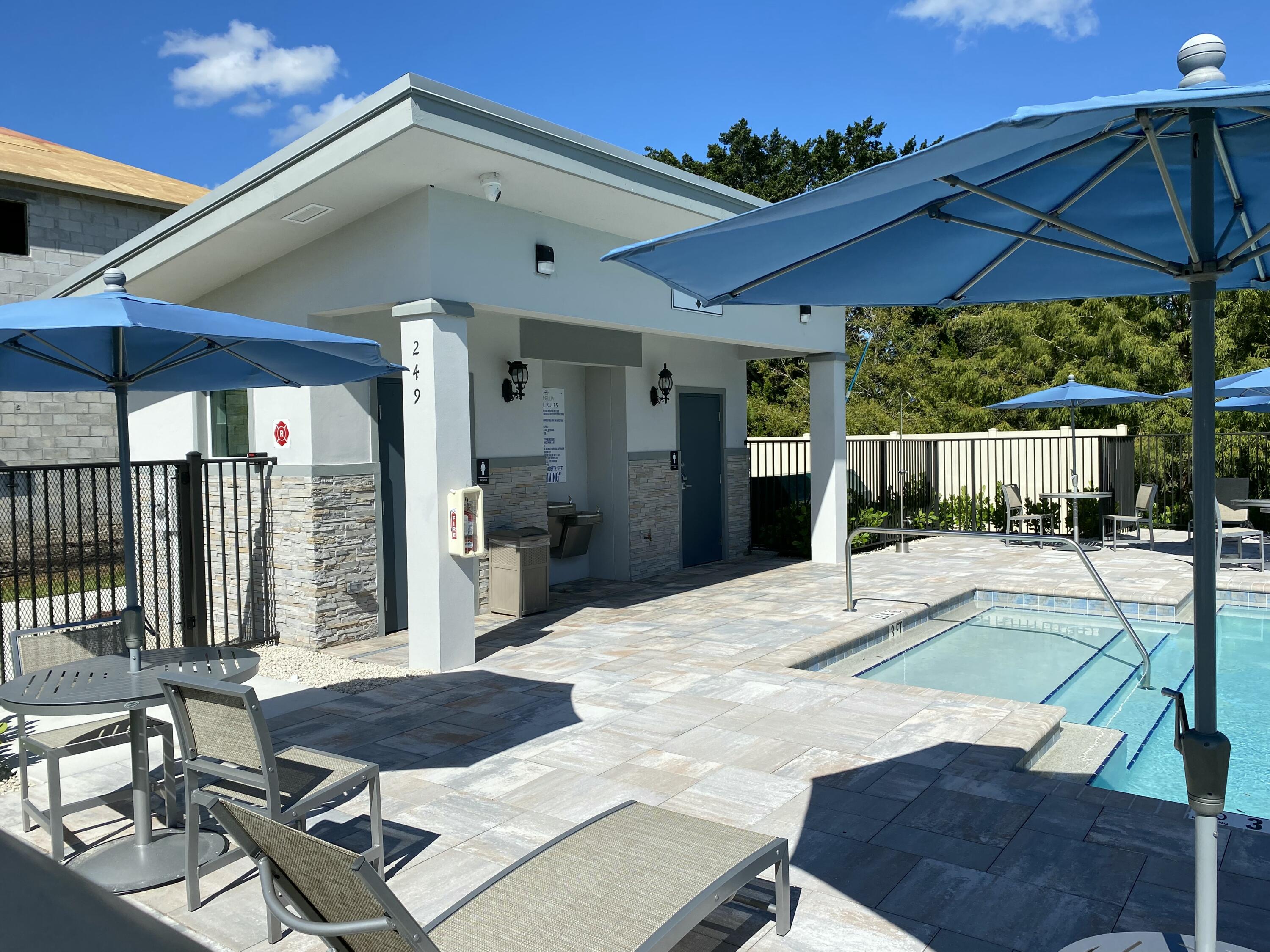 2788 Tennis Club Drive, Unit 102 West Palm Beach, FL 33417 - Photo 25 of 26 a view of a patio with a table and chairs under an umbrella
