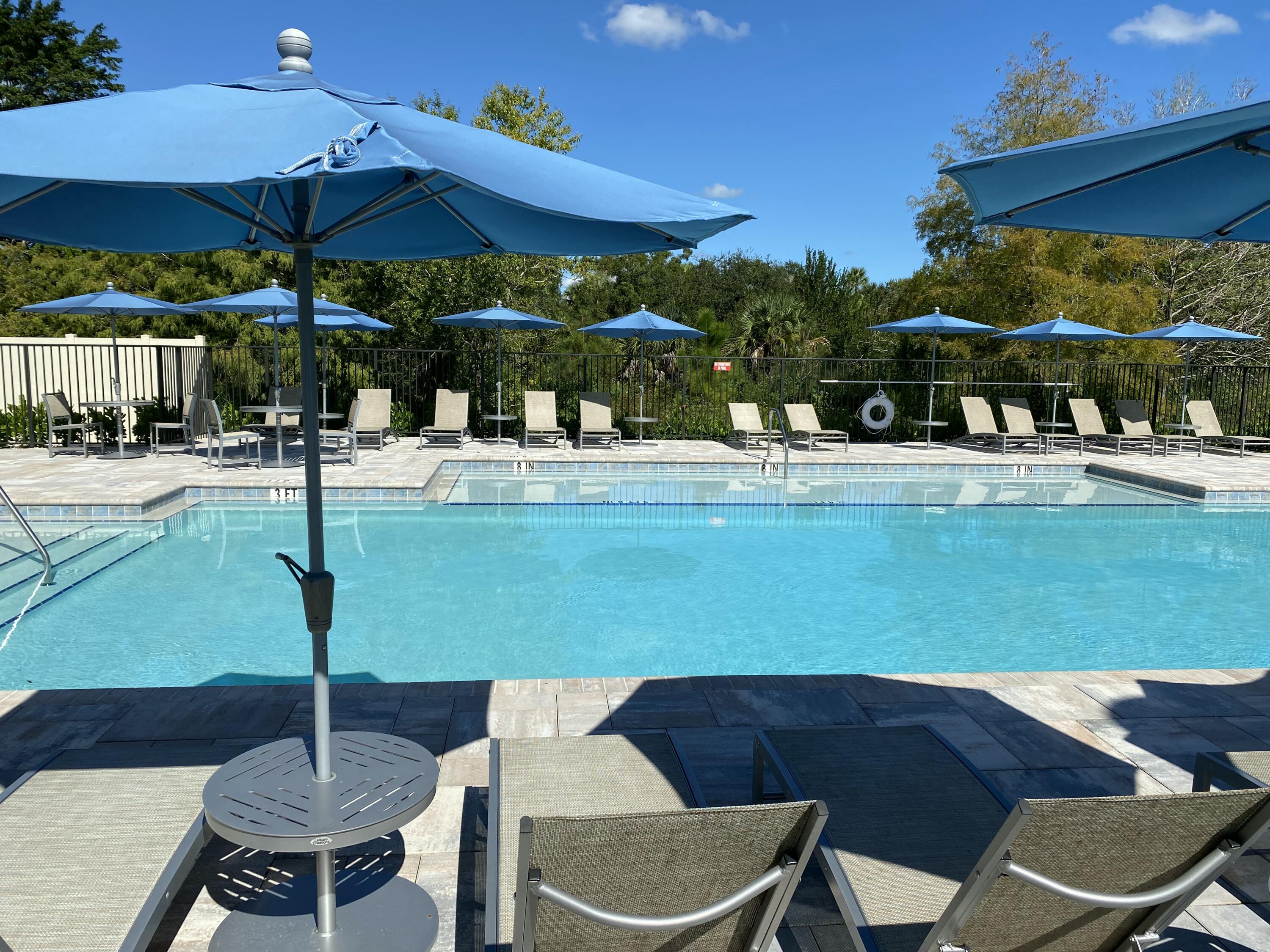 2788 Tennis Club Drive, Unit 102 West Palm Beach, FL 33417 - Photo 26 of 26 a view of a patio with table and chairs under an umbrella