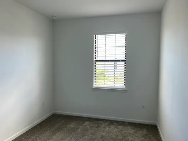 an empty room with windows and chandelier