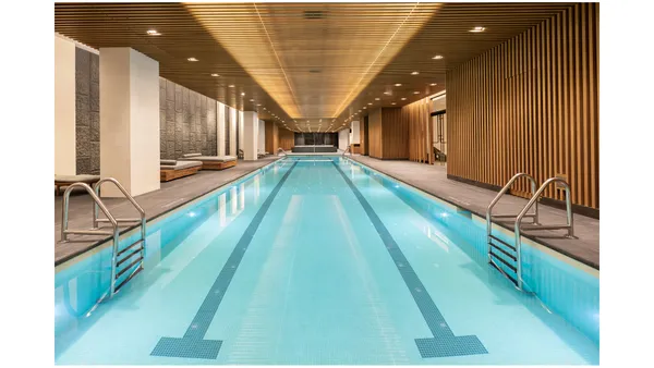 a living room with stainless steel appliances furniture a rug and a large window