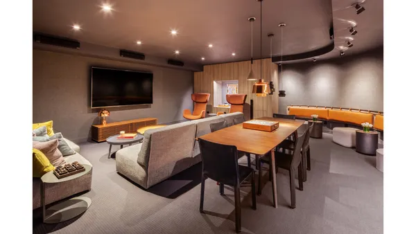 a living room with furniture a flat screen tv and kitchen view