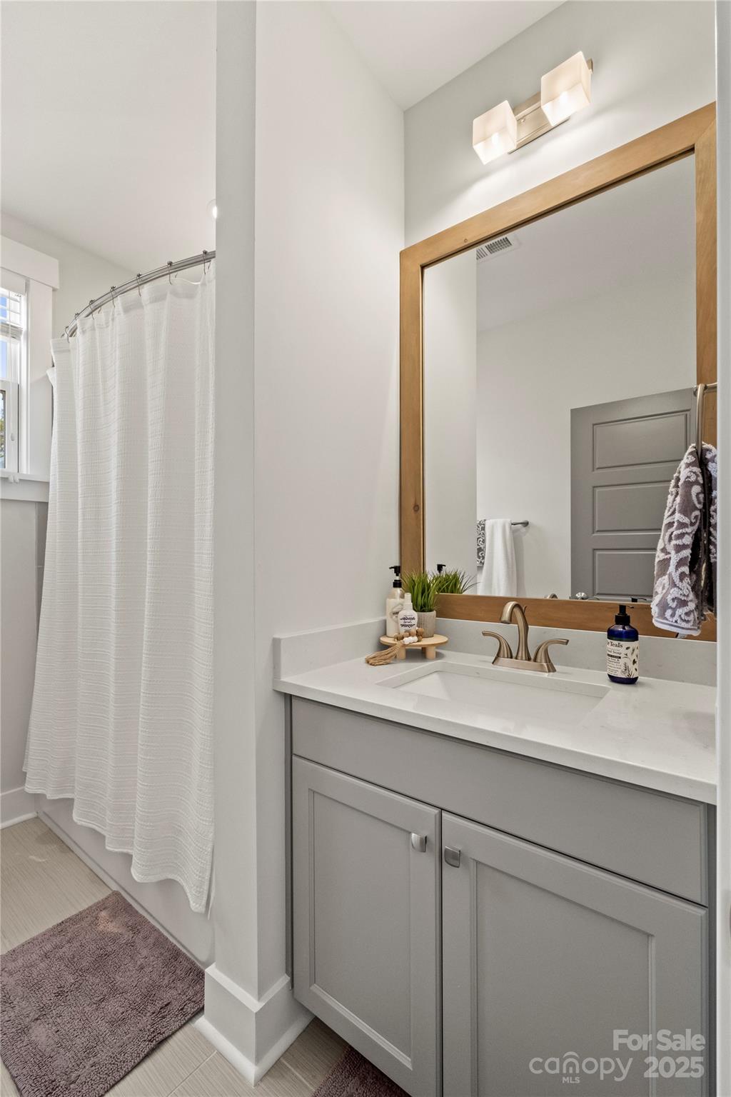 907 Millbrook Road Charlotte, NC 28211 - Photo 39 of 46 a bathroom with a double vanity sink and a mirror
