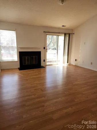 an empty room with wooden floor and fireplace