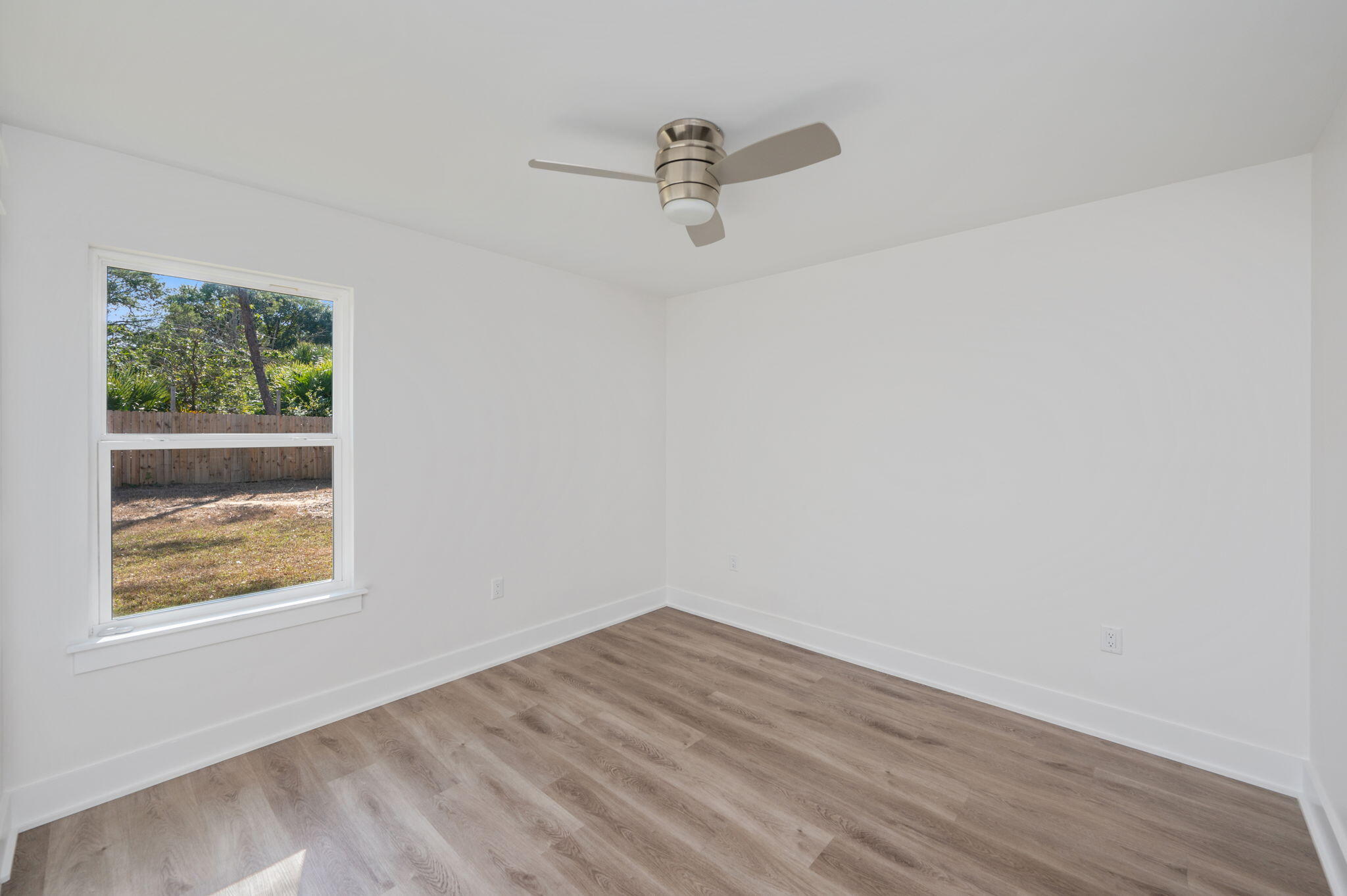 68 Iris Lane DeFuniak Springs, FL 32433 - Photo 13 of 34 an empty room with wooden floor and windows