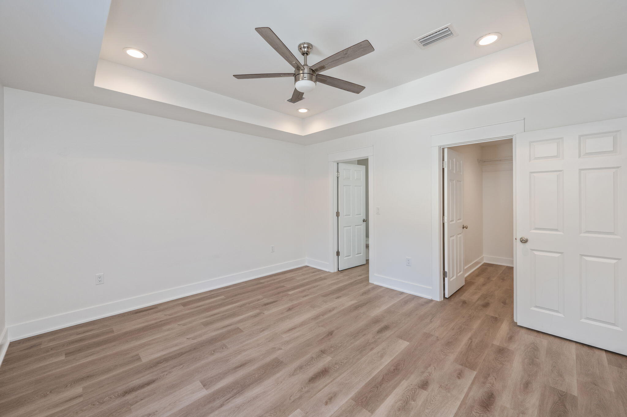 68 Iris Lane DeFuniak Springs, FL 32433 - Photo 25 of 34 an empty room with wooden floor ceiling fan and windows