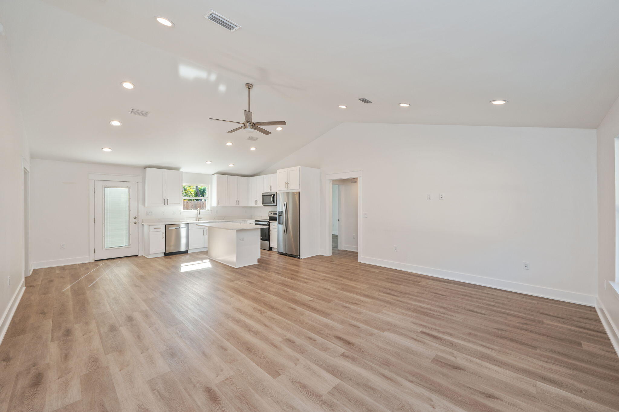 68 Iris Lane DeFuniak Springs, FL 32433 - Photo 5 of 34 a view of an empty room with wooden floor kitchen view and a window