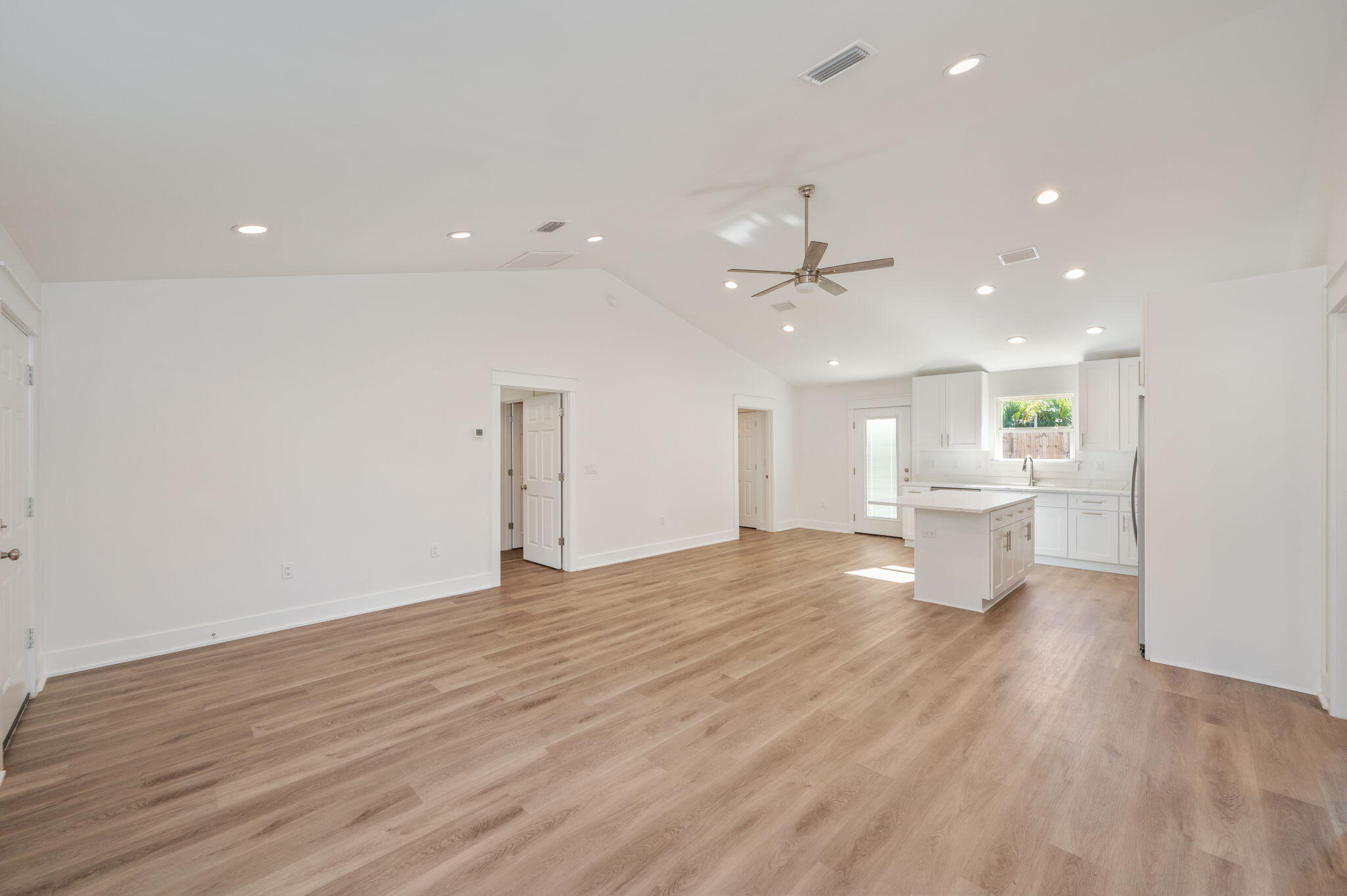 68 Iris Lane DeFuniak Springs, FL 32433 - Photo 6 of 34 a view of an empty room with wooden floor and a kitchen